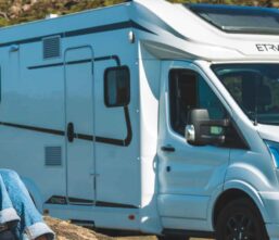 Girl sitting outside motorhome in the sun