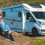 Girl sitting outside motorhome in the sun